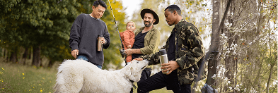 People gathered outdoors in a park with an animal